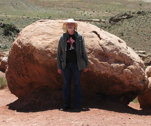 Mark leaning against a big red rock